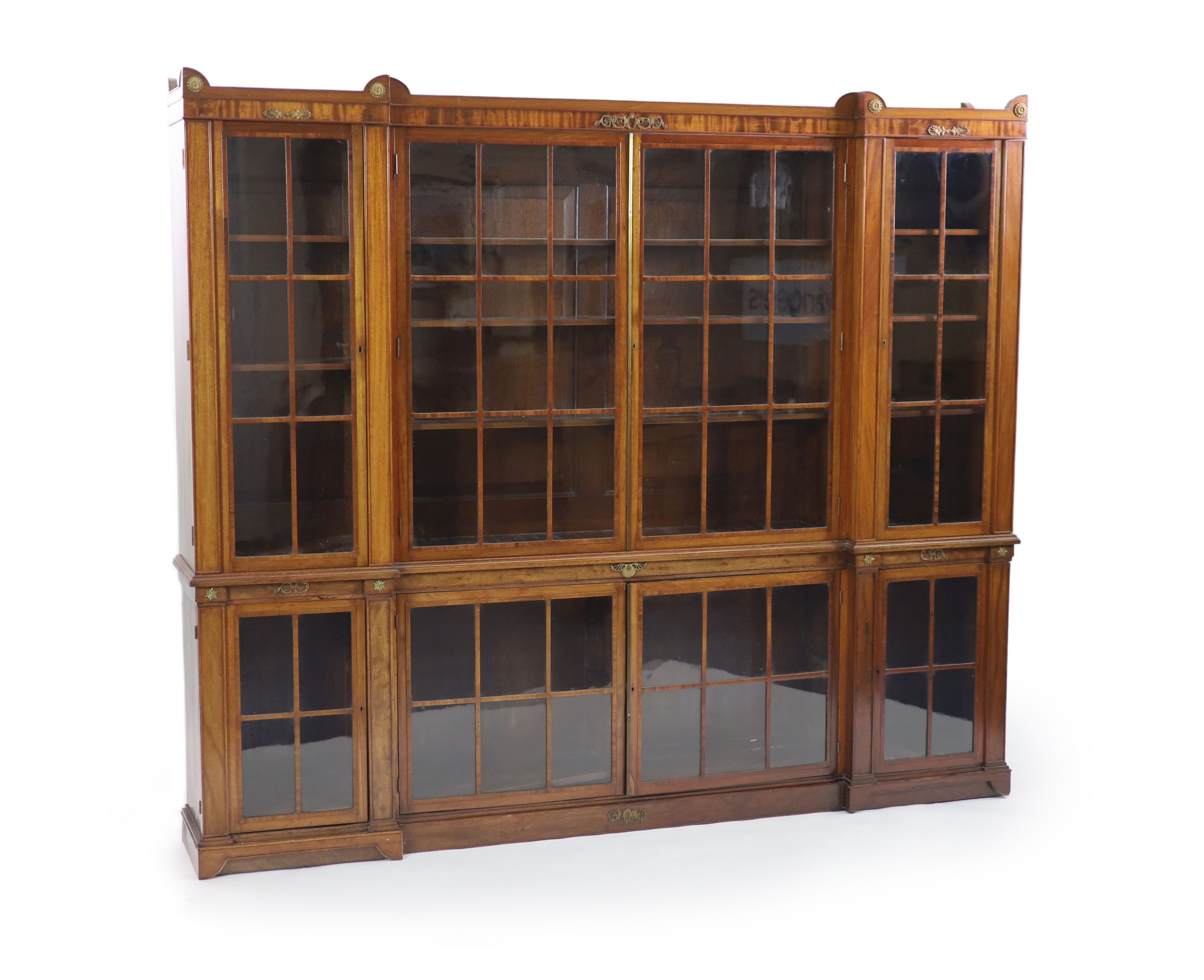 A Regency style mahogany inverse breakfront bookcase H 205cm. W 240cm. D 38cm.